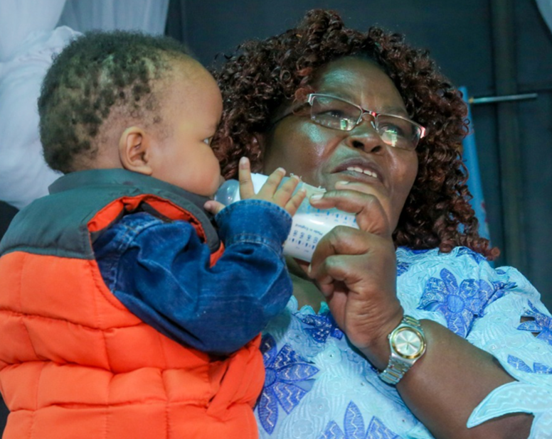 Caregiver feeding a baby with a bottle