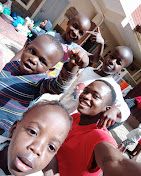 Children smiling for a group selfie
